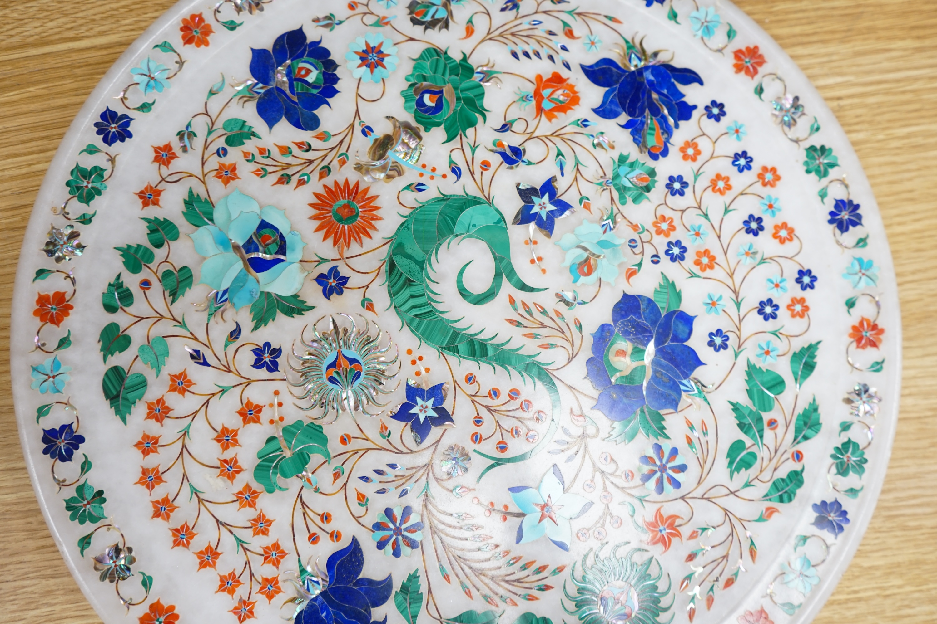 An Indian alabaster and pietra dura tray, inlaid with stylised flowers, 35cm in diameter. Condition - good